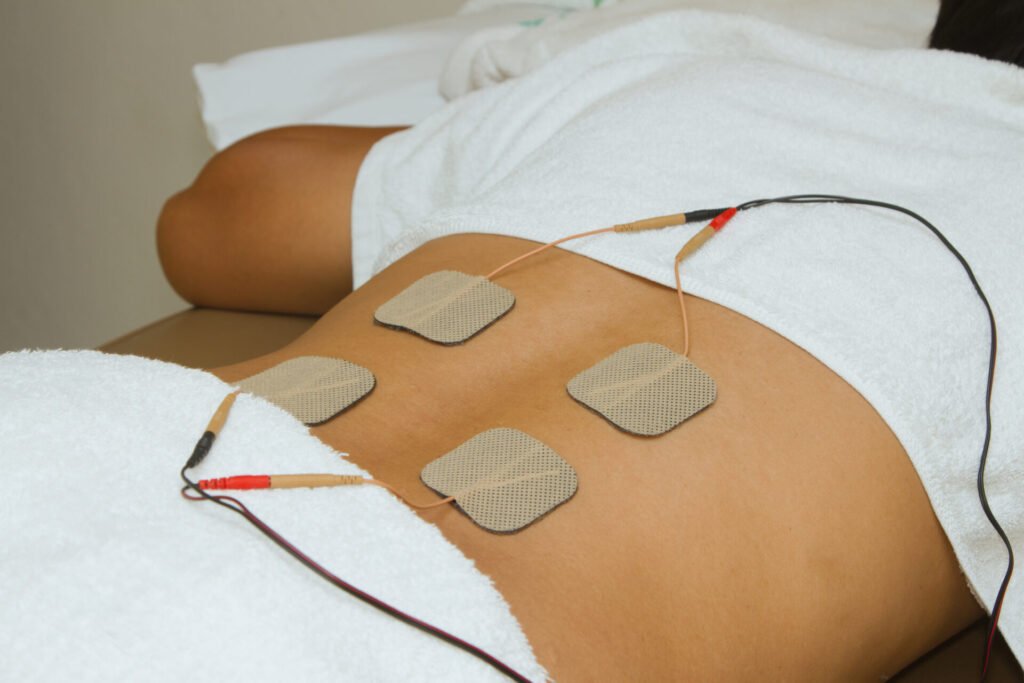 Patient applying electrical stimulation therapy ( TENS ) on his